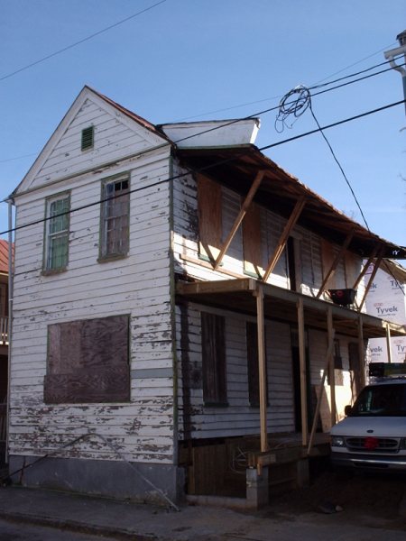 Three-quarter view showing the full extent of exterior deterioration before work began.