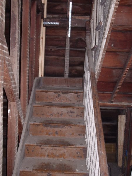 The original stair stripped to bare wood, showing intact treads and balusters worth saving.