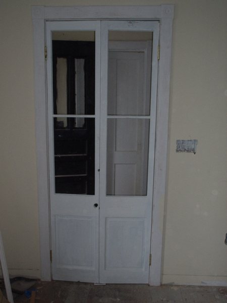 Original interior French doors as found: paint-checked, with wavy old glass intact.