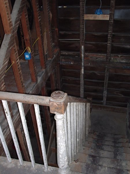 Upper landing before: exposed lath and a paint-encrusted newel post.